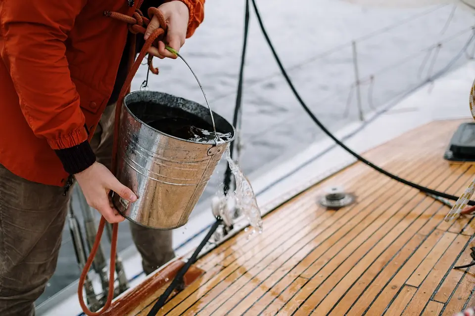 Washing a boat deck with a bucket of water