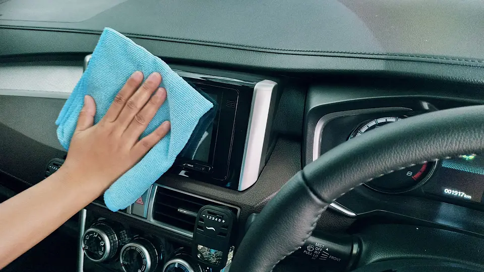 Blue microfiber cloth cleaning the dashboard and screen