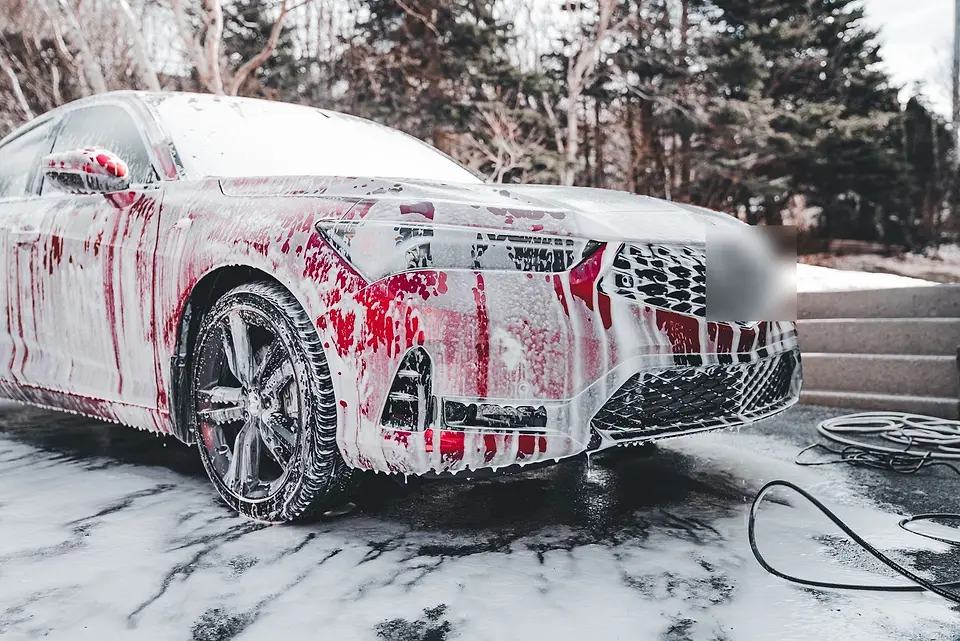 Camioneta roja en espuma espesa en un día de nieve