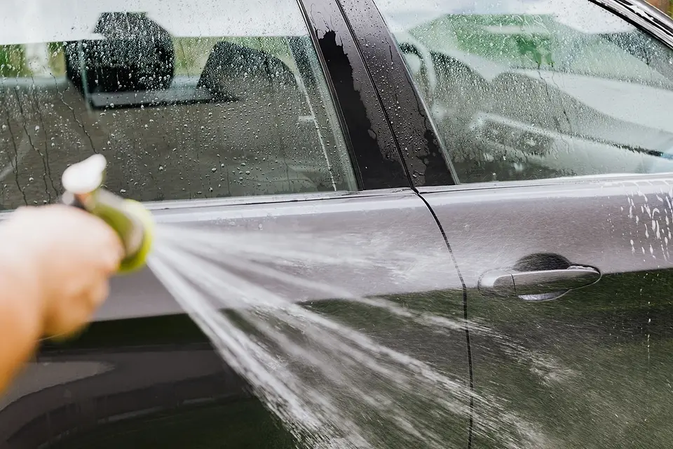 Water rinsing soap off a car door