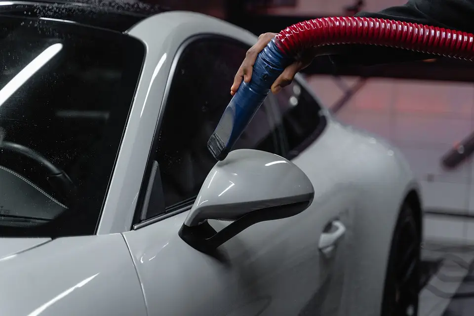 Vacuum hose reaching inside a white car