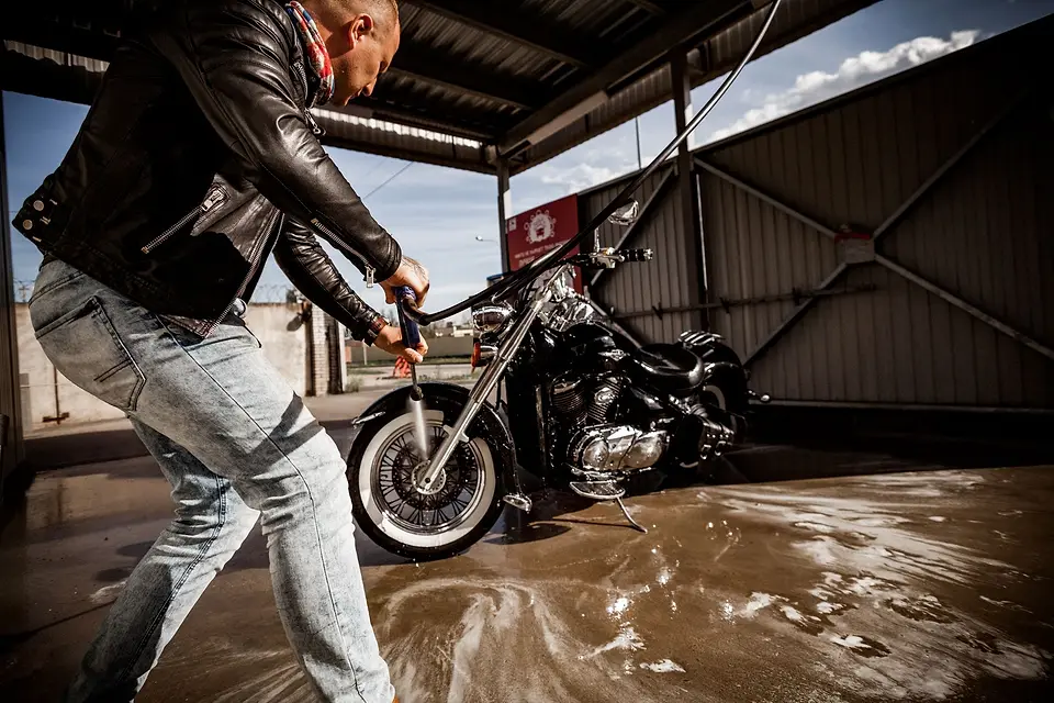 Rider rinsing a cruiser motorcycle