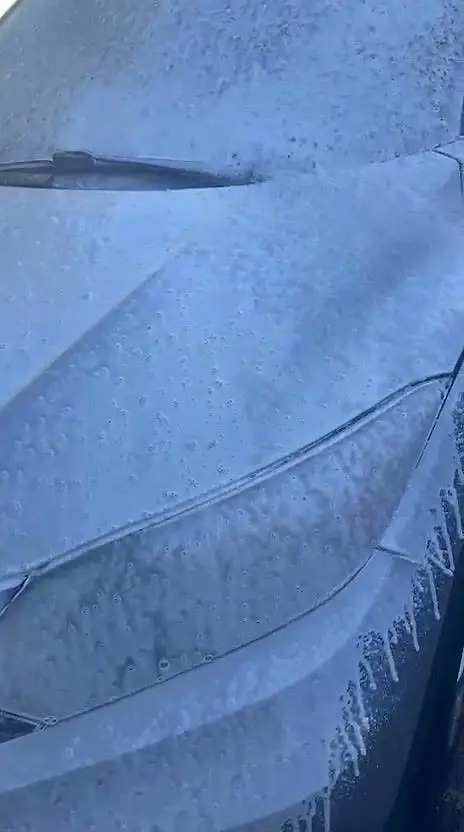 Foam covering the front wheel and fender during a mobile wash