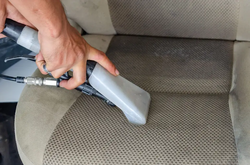 Máquina de extracción limpiando a fondo un asiento de tela