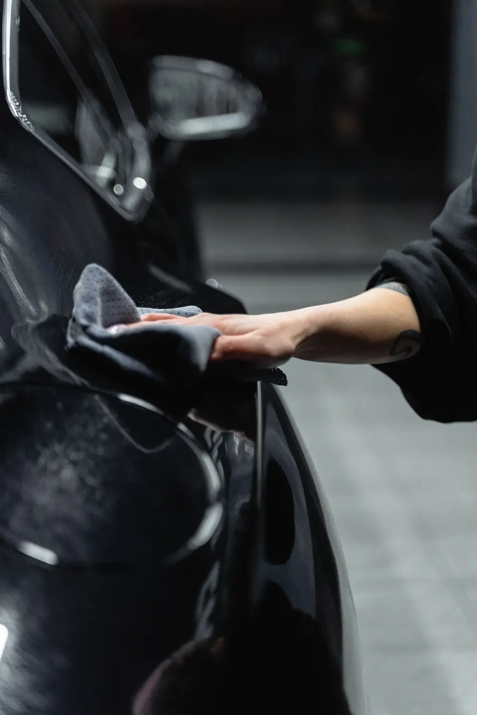 Microfiber towel gliding over glossy black paint