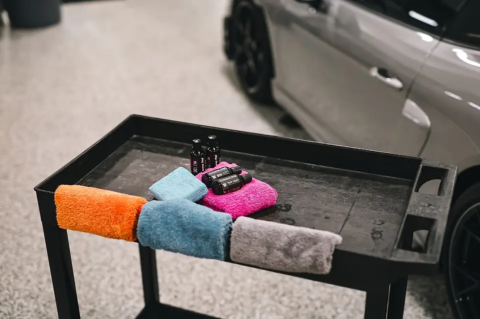 Clean microfiber towels on a detailing cart