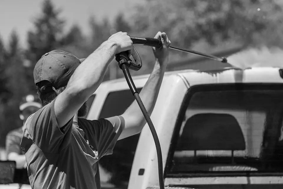 Man pressure-washing a truck